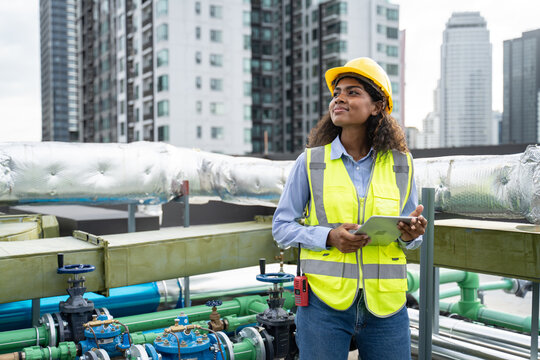 service engineer woman dark skin wearing uniform and safety helmet under inspection and checking pro