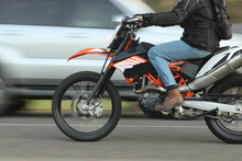 Close Up Of A Man Riding A Motorbike Past A Car