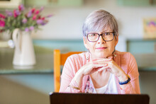 Portrait Of A Senior Woman With Glasses Looking At The Camera Inside Her Home