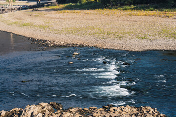 Low flowing river bed. Reduction of river water in summer. Drought theme.