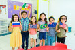 © AntonioDiaz - Happy preschoolers showing diverse country flags