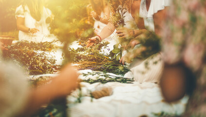 View of women making wreaths with beautiful flowers.