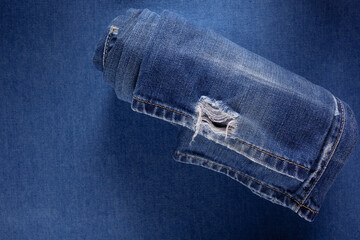 Wall Mural - Folded blue jeans denim background texture. Jeans fabric material surface