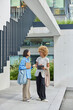 © wayhome.studio  - Full length shot of diverse women meet together to discuss startup project hold tablet and spiral notebook dressed in stylish clothes carry bags pose near urban building outdoors. Meeting of students
