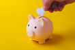 © Verrone - Saving money. The hand puts a heart in a piggy bank. Salary retention.