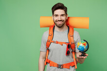 Young Fun Traveler White Man Carry Backpack Stuff Mat Hold Earth World Globe Isolated On Plain Green Background. Tourist Leads Active Lifestyle Walk On Spare Time Hiking Trek Rest Travel Trip Concept