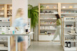 © pressmaster - Blurry motion of two young women moving along displays with self care items such as bodycare, skincare, nailcare and makeup products