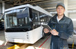 © scharfsinn86 - Serviceman with digital tablet on the background of the bus in the garage