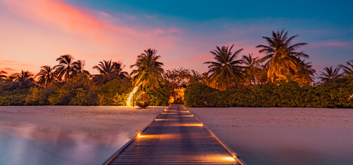 Wall Mural - Amazing sunset panorama at Maldives. Luxury resort pier pathway, soft led lights into paradise island. Beautiful evening sky and colorful clouds. Romantic beach background for honeymoon vacation