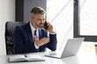 © Prostock-studio - Stressed Middle Aged Businessman Talking On Cellphone And Using Laptop In Office