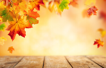autumn concept with red-yellow maple leaves. wooden table and colorful falling leaves over blurred b