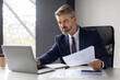 © Prostock-studio - Busy Mature Businessman Working With Laptop And Documents In Office