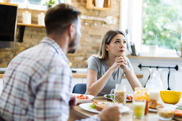 Wall Mural - Young couple arguing during breakfast time at home