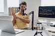 © gstockstudio - Young man in headphones using microphone and gesturing while recording his business podcast