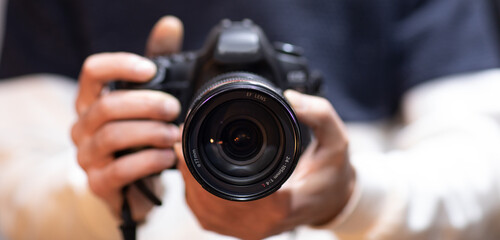 man holds modern digital black camera