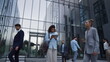 © stockbusters - Focused woman use tablet in downtown area. Diverse employees rush to workplace.