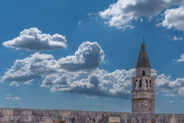 backlighted church tower in the sky with clouds, svetvincenat, croatia