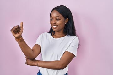 Sticker - African young woman wearing casual white t shirt looking proud, smiling doing thumbs up gesture to the side