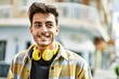 © Krakenimages.com - Handsome hispanic man smiling happy and confident at the city wearing headphones with modern style