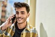 © Krakenimages.com - Handsome hispanic man smiling happy and confident at the city speaking on the phone and drinking a cup of coffee