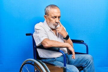 Poster - Handsome senior man with beard sitting on wheelchair pointing to the eye watching you gesture, suspicious expression