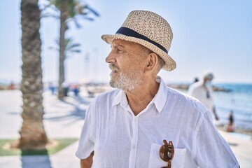 Canvas Print - Senior man smiling confident wearing summer hat at seaside