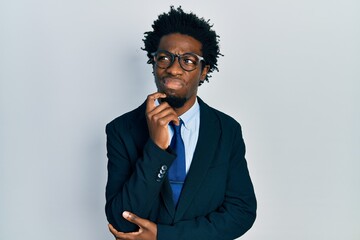 Poster - Young african american man wearing business suit serious face thinking about question with hand on chin, thoughtful about confusing idea