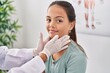 © Krakenimages.com - Woman and girl doctor and patient examining throat at clinic