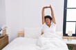 © Krakenimages.com - African american woman waking up stretching arms at bedroom