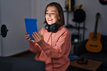 Sticker - Middle age woman musician holding touchpad at music studio