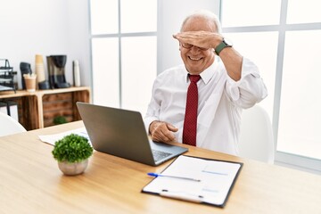 Canvas Print - Senior man working at the office using computer laptop covering eyes with hand, looking serious and sad. sightless, hiding and rejection concept