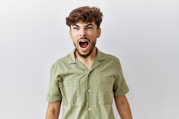 Poster - Young arab doctor man standing over isolated background angry and mad screaming frustrated and furious, shouting with anger. rage and aggressive concept.