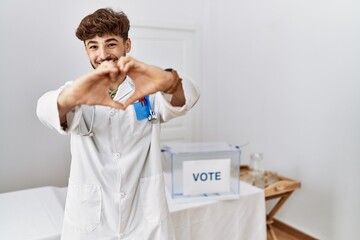 Sticker - Young arab doctor man at political election by ballot smiling in love showing heart symbol and shape with hands. romantic concept.