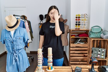 Wall Mural - Young asian woman working as manager at retail boutique covering one eye with hand, confident smile on face and surprise emotion.