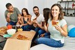 © Krakenimages.com - Group of young hispanic friends smiling happy eating italian pizza sitting on the sofa at home.