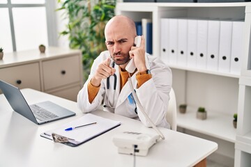 Sticker - Young bald man with beard working on telephone appointment pointing with finger to the camera and to you, confident gesture looking serious