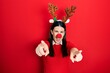 Leinwandbild Motiv Young hispanic woman wearing deer christmas hat and red nose pointing to you and the camera with fingers, smiling positive and cheerful