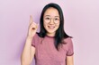 Young chinese girl wearing casual clothes and glasses pointing finger up with successful idea. exited and happy. number one.