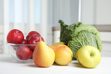 Wall Mural - fresh fruits and savoy cabbage on white wooden table indoors. food poisoning concept