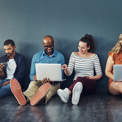 Aufkleber - Group of happy business people sharing information on wireless technology in a row at an office together. Creative professionals sitting and talking using devices in a waiting room together at work