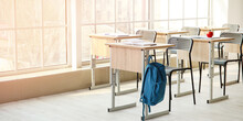Interior Of Modern Empty Classroom With Hanging Backpack On Desk