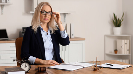 Wall Mural - Mature female judge sitting at table in office