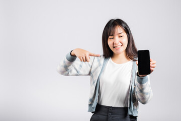 Wall Mural - Woman excited pointing finger to a smartphone screen studio shot isolated white background, happy young female smiling showing something product on mobile phone screen