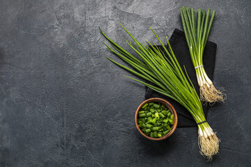 Wall Mural - Composition with fresh green onion on dark background