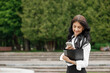 © Yuliia - European businesswoman use mobile phone outdoors. Beautiful focused young girl wear formal suit.