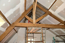 Plasterboard Fitted Over New Roof Insulation Highlighting Exposed Beams And Trusses
