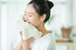 タオルで顔を拭く若い女性