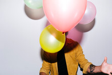 Man With Balloons Standing Against White Background