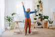 © Westend61 - Happy freelancer with arms raised standing at home office