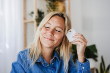 Smiling Woman With Eyes Closed Holding Credit Card